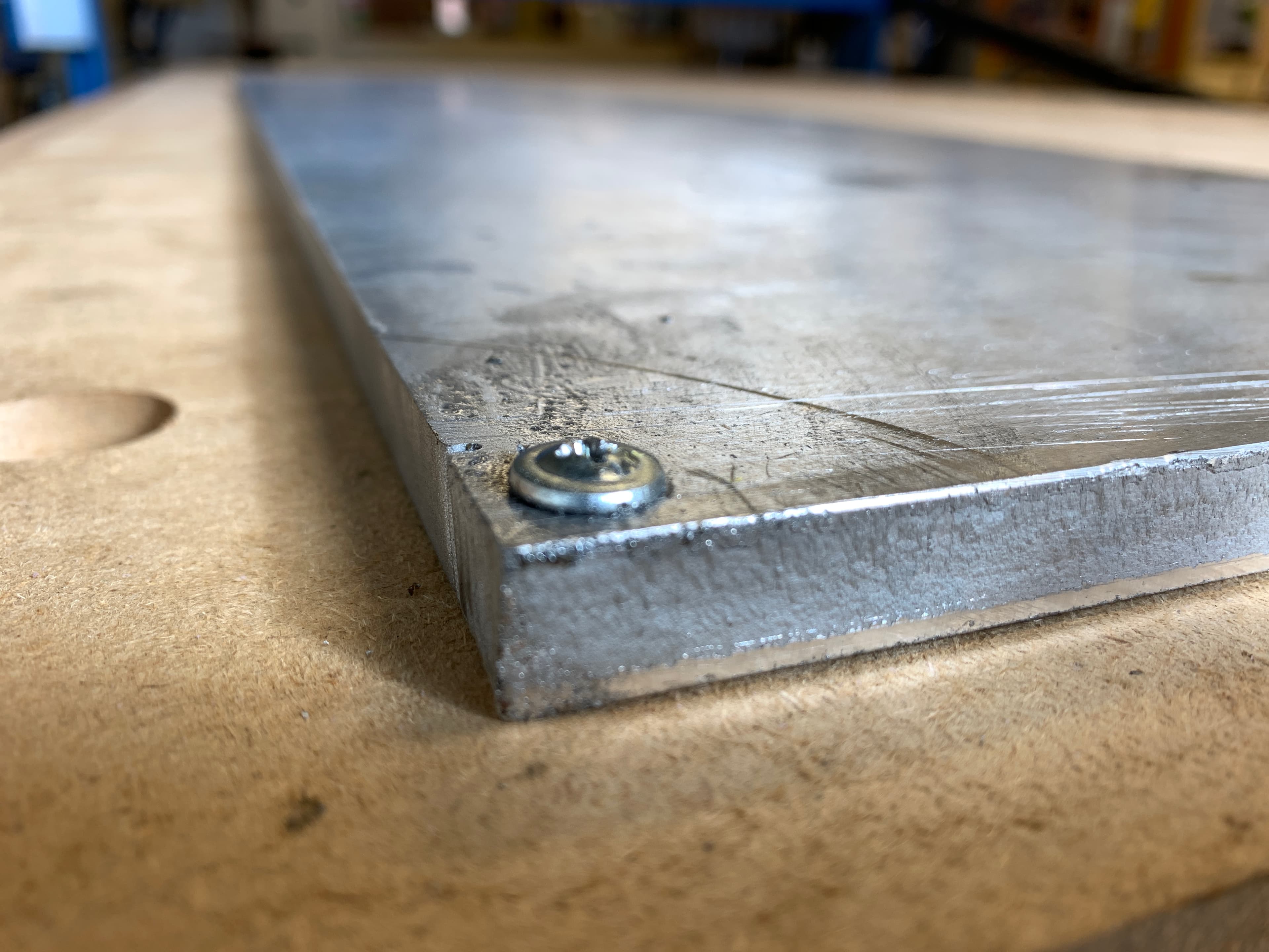 A screw on one corner of stock aluminum plate.
